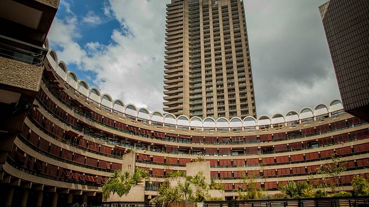 Inside courtyard of the Barbican Centre with a tall building standing at the back