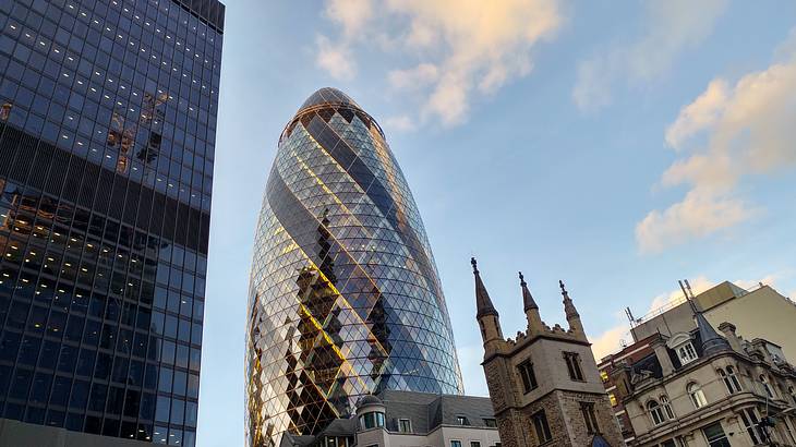 View of The Gherkin, a skyscraper at sunset behind city buildings