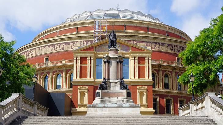 Royal Albert Hall's entrance with a statue in front, as seen from its south steps