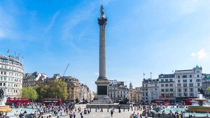 Nelson's Column in the middle of a busy Trafalgar Square on a sunny day