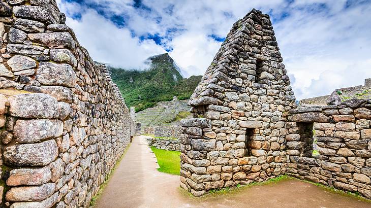 Stacks of old ruins in Machu Picchu with green hills behind