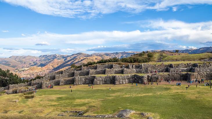Ancient stone walls from far away, surrounded by grass and mountains