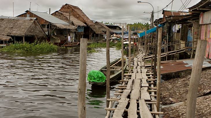 Wooden homes along a river in a village on a cloudy day