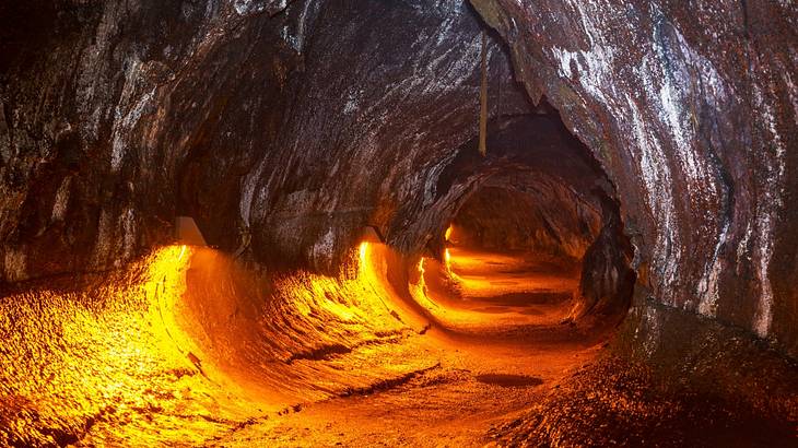 The inside of a dark natural cave tunnel formed by molten lava
