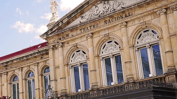 View of a beautiful theatre's facade under a partly cloudy sky View of a beautiful theatre's facade under a partly cloudy sky