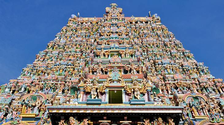 The exterior of a temple from below covered in colourful statues