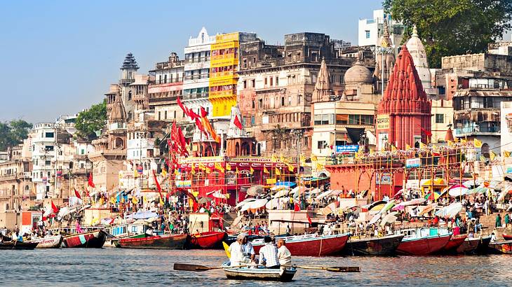 People in boats on a river, lined by colourful old buildings