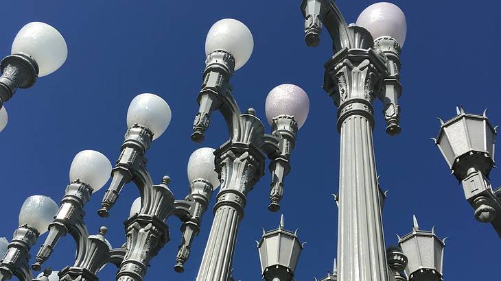 Bottom view of vintage street lamps under a blue cloudless sky