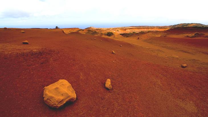 Barren plateau with rocks and sand dunes in orange hues