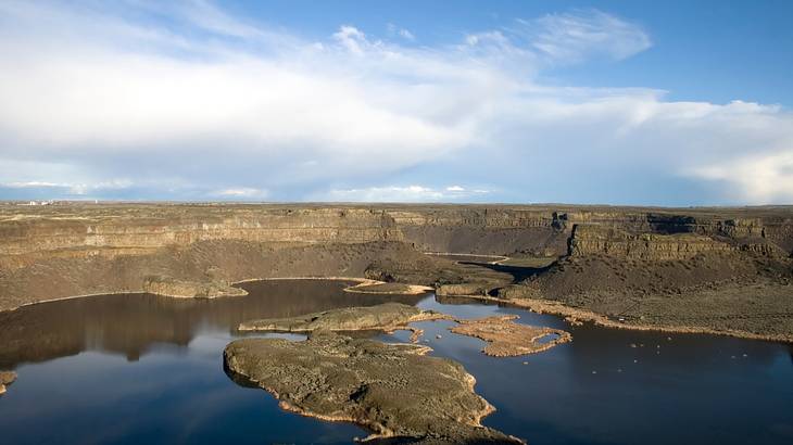 Aerial of barren rocky cliffs surrounded by a lake Aerial of barren rocky cliffs surrounded by a lake