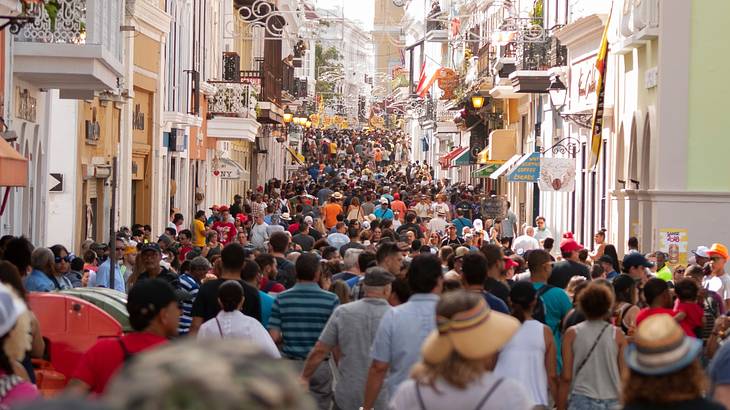 A street lined with buildings and packed with people during a festival