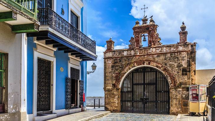 A small chapel located at the end of a cobblestone street lined by terraced houses A small chapel located at the end of a cobblestone street lined by terraced houses