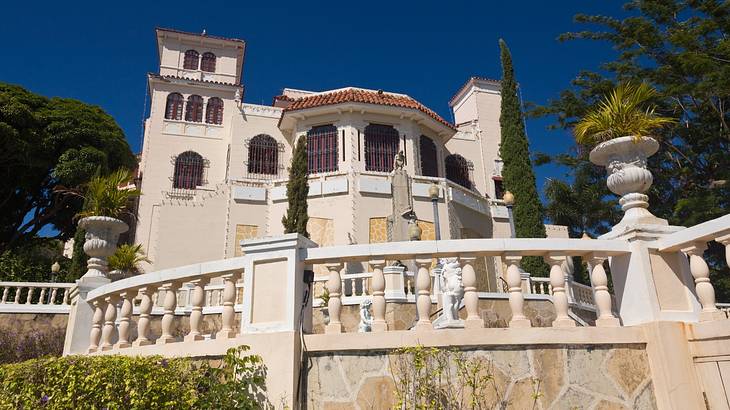 A Spanish Revival-style structure with a terrace and big white stone vases A Spanish Revival-style structure with a terrace and big white stone vases