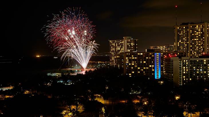Fireworks in the night sky surrounded by illuminated skyscrapers Fireworks in the night sky surrounded by illuminated skyscrapers