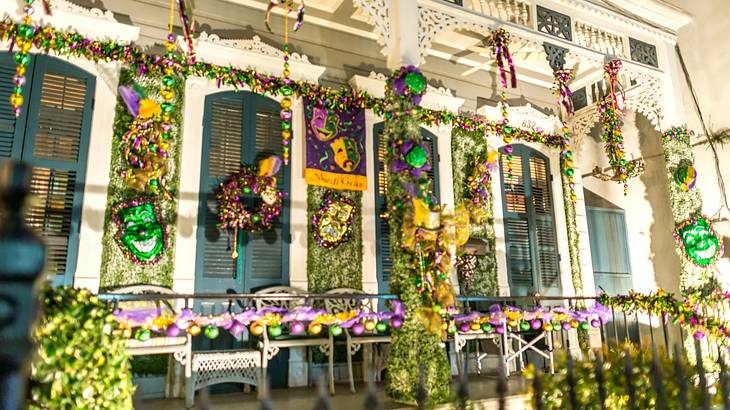 A house decorated with yellow, green, and purple Mardi Gras decorations