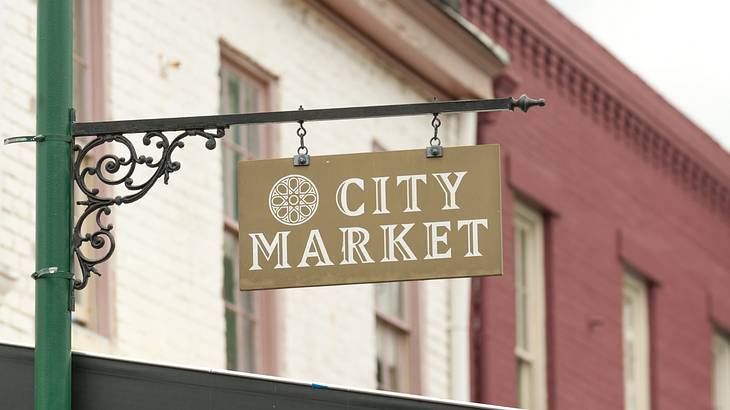 A green sign post in front of buildings with a sign that says City Market A green sign post in front of buildings with a sign that says City Market