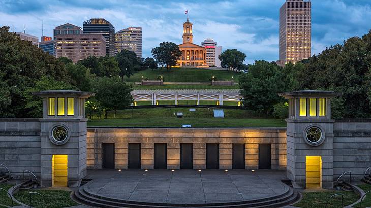 A park with buildings and a state capitol building in the background