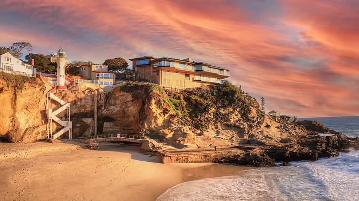 Beach mansions on a rocky cliff overlooking the sand and ocean at sunset