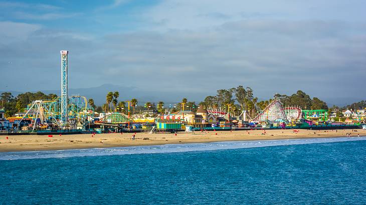 View from the sea of a sandy beach with a colorful amusement park