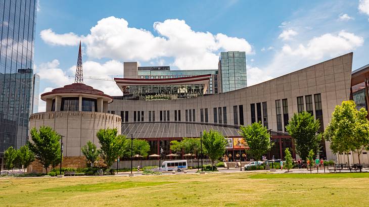 A rectangular building with a rotunda attached and grass and trees in front of it