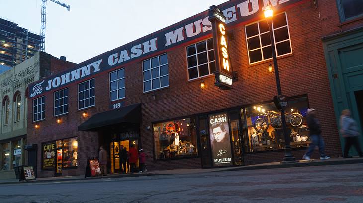 A red brick building with a Johnny Cash Museum sign and a street in front of it