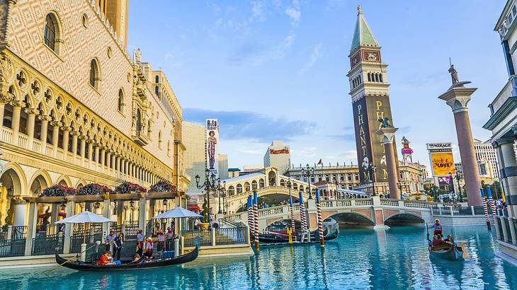 Water with gondolas on it and Italian-style bridges and buildings surrounding it Water with gondolas on it and Italian-style bridges and buildings surrounding it