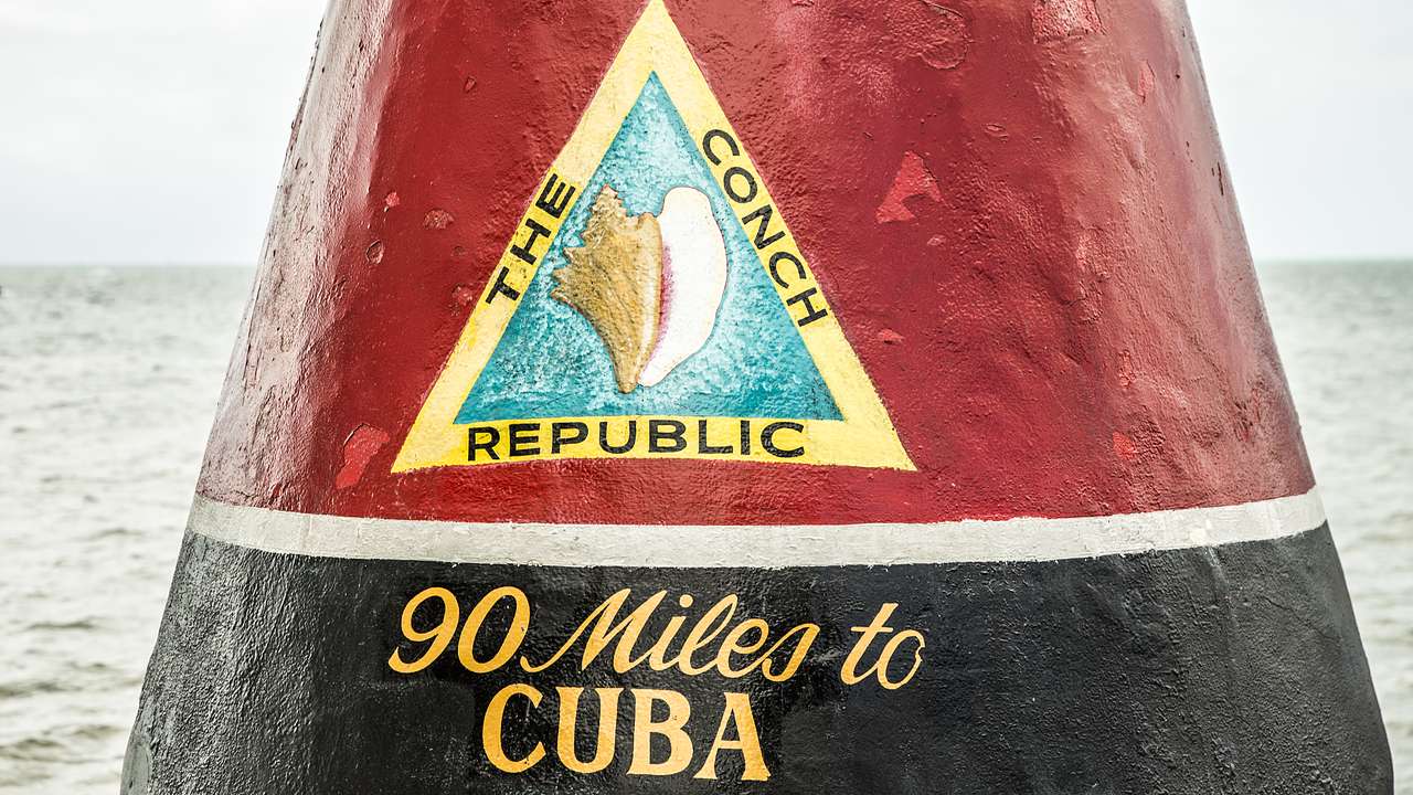 A black and red marker with a Conch Republic sign and the words 90 Miles to Cuba