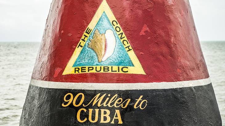 A black and red marker with a Conch Republic sign and the words 90 Miles to Cuba