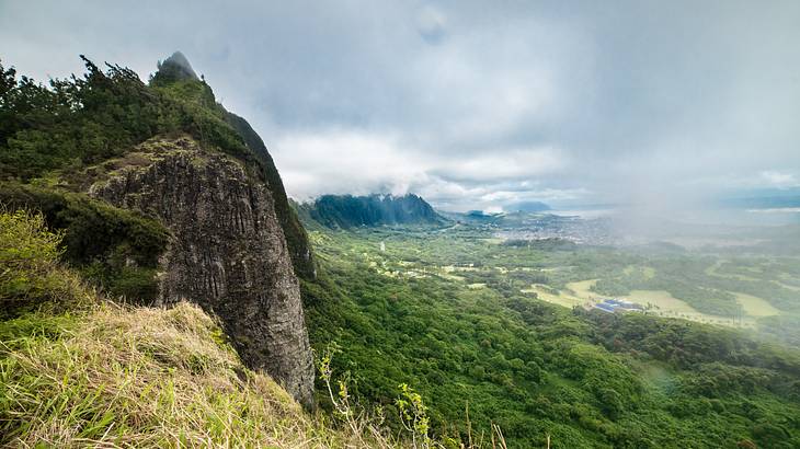 The view from a greenery-covered mountain with storm clouds above