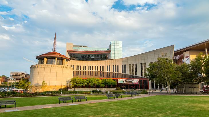 A museum building with a rotunda building and grass and trees in front of it