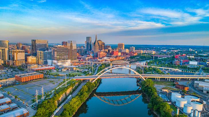 A view of Nashville with a bridge over a river and cityscape in the background