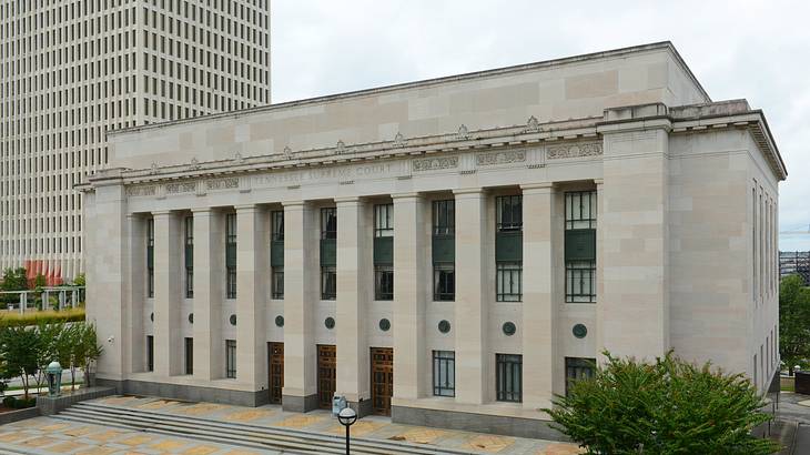 A court building with pillars on the front and steps and trees in front of it