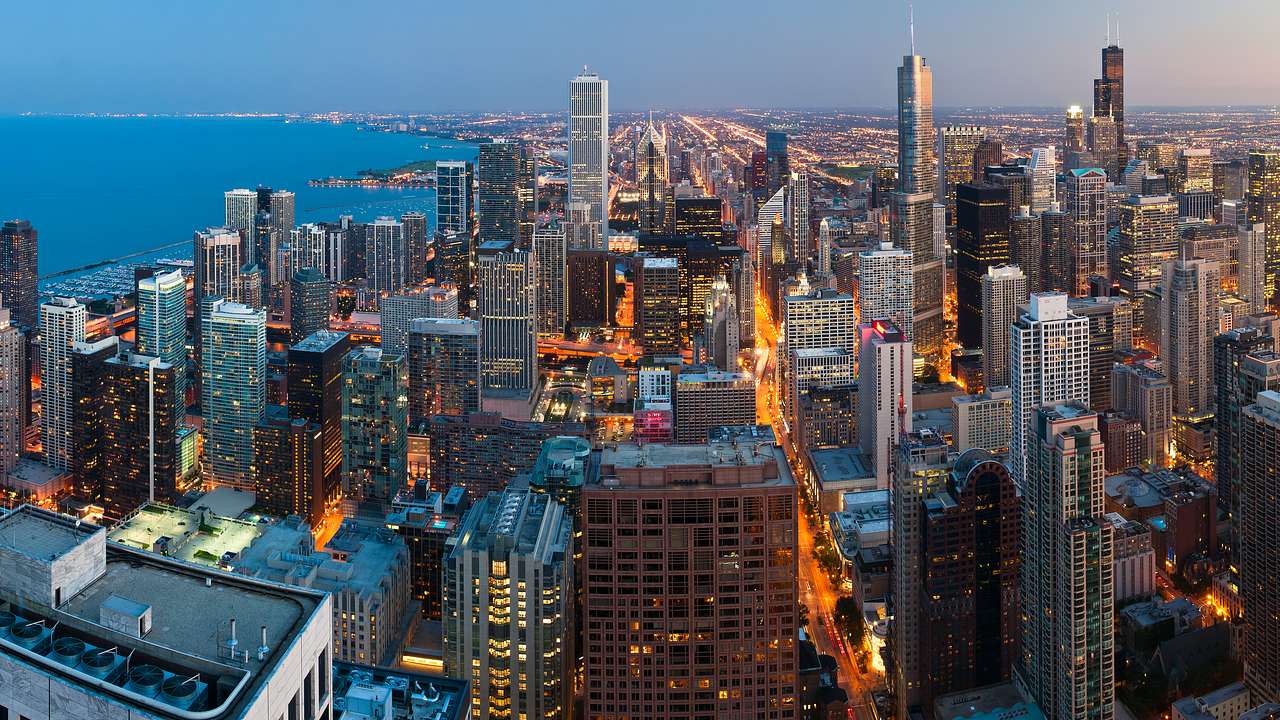 An aerial view of skyscrapers in Chicago at night with a lake to the side