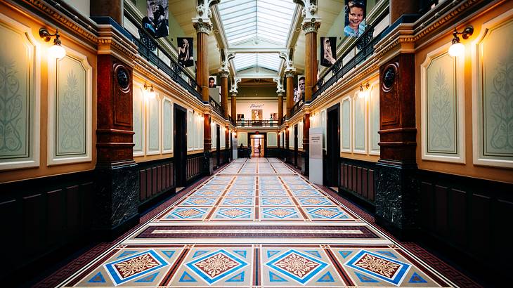 A museum hallway with colorful tiles on the floor and paneled walls