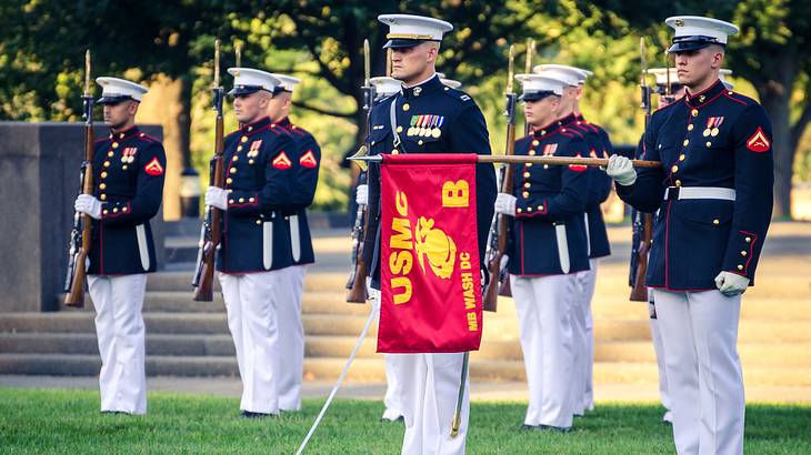 Ten soldiers in uniform standing on the grass in a parade