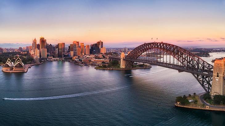 Aerial view of a bridge and buildings by the shoreline at sunrise Aerial view of a bridge and buildings by the shoreline at sunrise