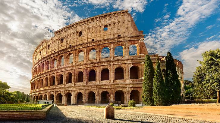 The exterior of an ancient amphitheater on a partly cloudy day from below The exterior of an ancient amphitheater on a partly cloudy day from below