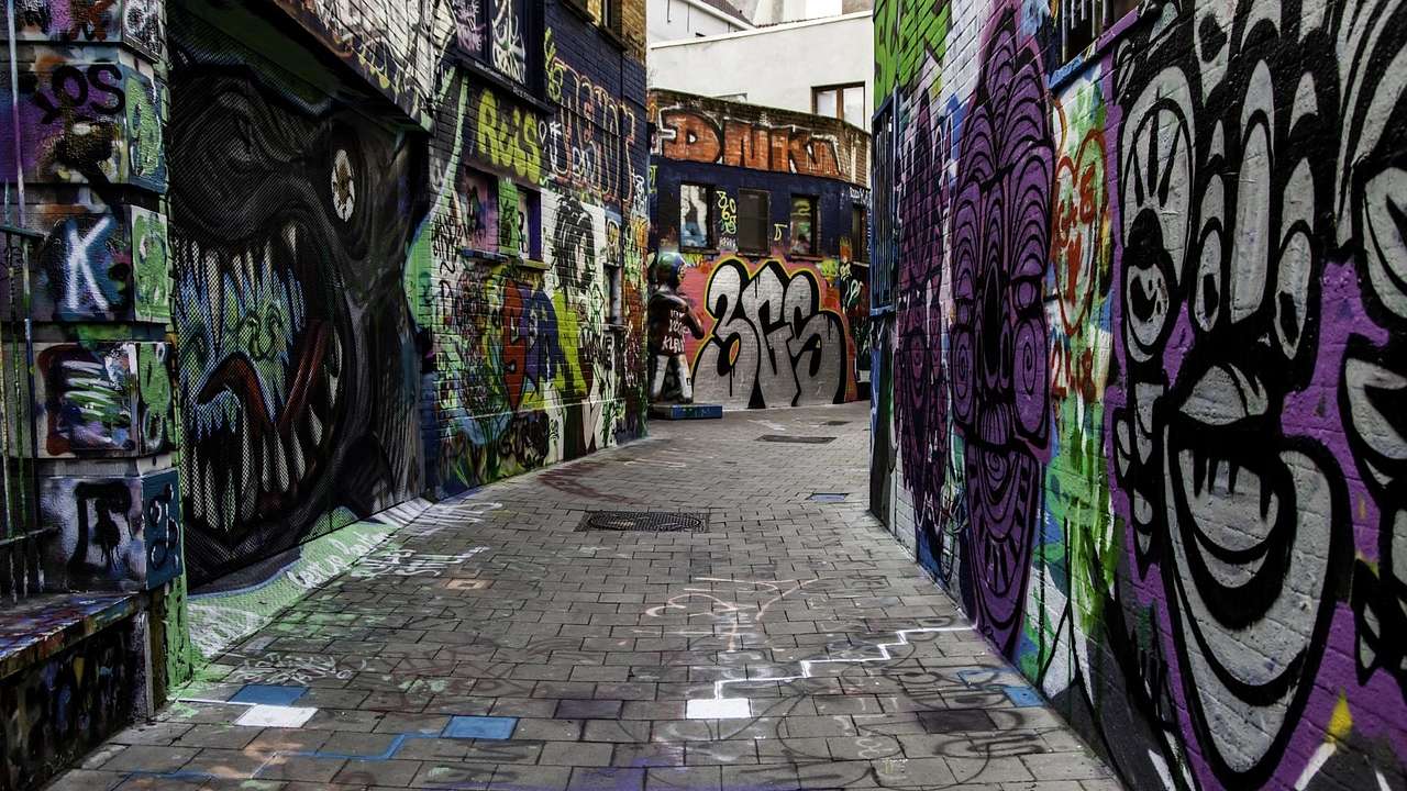 Dark graffiti-lined walls with a road running through the middle