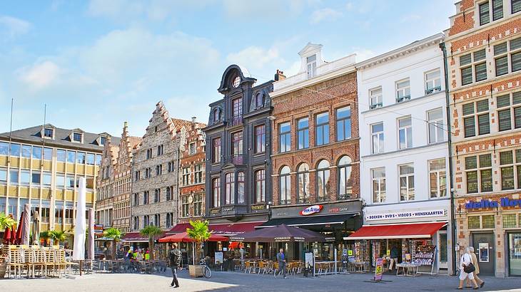 A square filled with pavement and tall buildings full of restaurants and shops