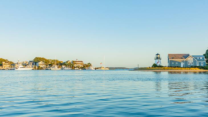 Ocean water with a coastal town and lighthouse on the horizon