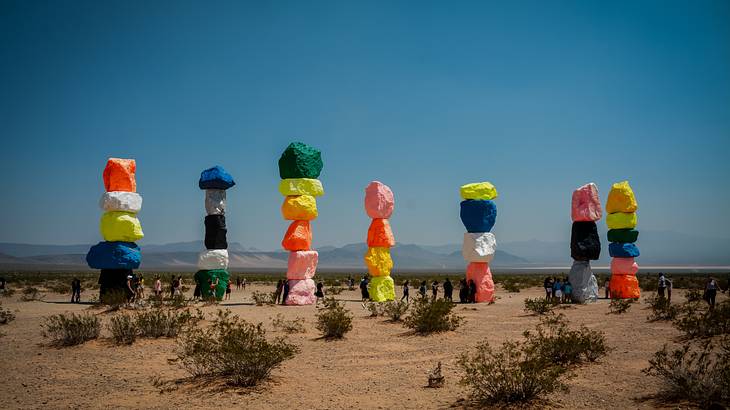 Seven towers of colored boulders in the desert under blue sky