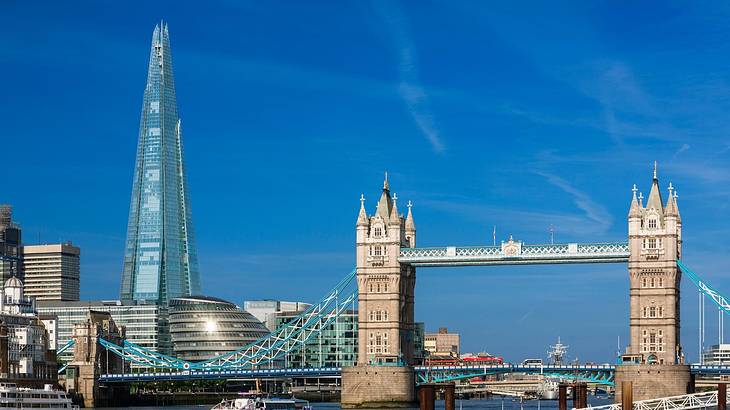 A modern skyscraper and buildings by a river. with a tower bridge on the right A modern skyscraper and buildings by a river. with a tower bridge on the right