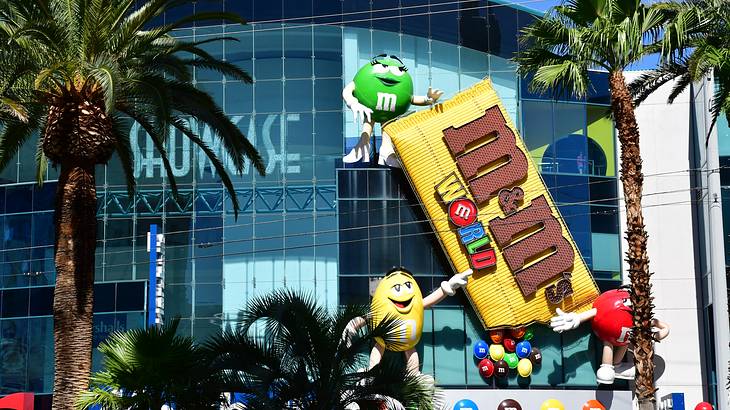 A large replica of an M&M candy bar on a storefront with M&M characters A large replica of an M&M candy bar on a storefront with M&M characters