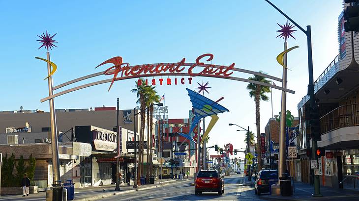 A sign with a Martini glass that says "Fremont East" over a road