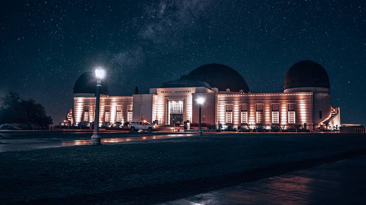 A lit-up structure with three domes against a starry night sky