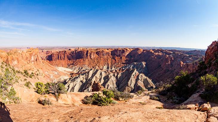 Looking down on many different layers of dry colorful rock canyons