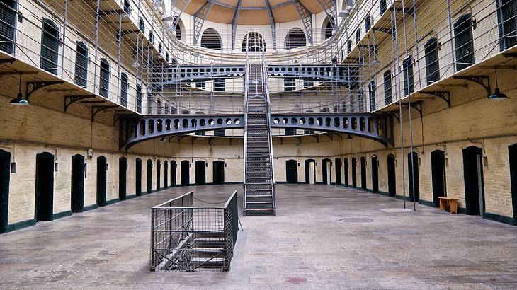 The interior of a multi-level prison with stairs and jail cells