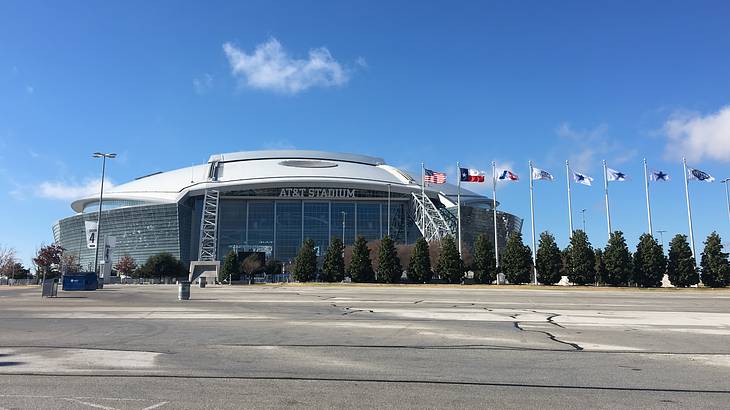 A football stadium with flags next to it and concrete in front of it