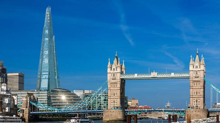 A modern skyscraper and buildings by a river. with a tower bridge on the right A modern skyscraper and buildings by a river. with a tower bridge on the right