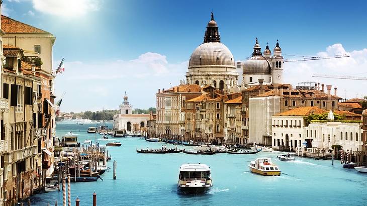 Church with a dome-shaped roof facing a canal with ferries